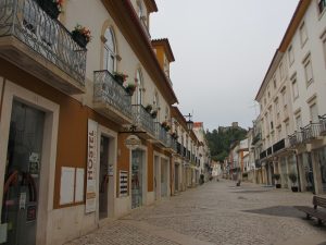 トマールのセルパ・ピント通り、左に”オスタル2300トマール”、奥に丘の上のキリスト教修道院